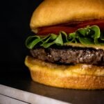 Mouthwatering close-up of a cheeseburger with fresh lettuce, tomato, and melted cheese.