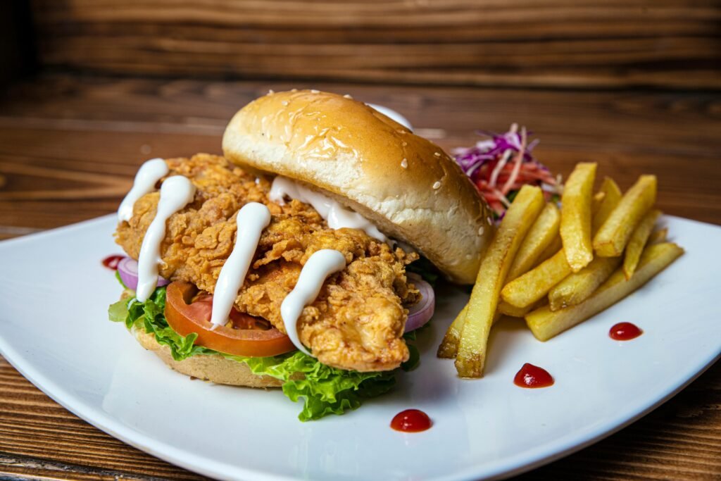 Delicious crispy chicken sandwich with fries on a plate, perfect for fast food lovers.